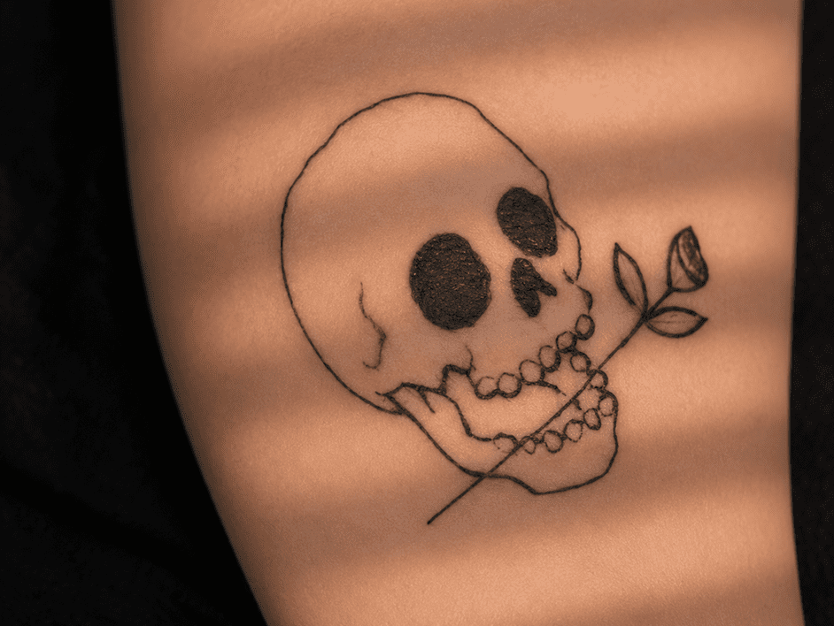 Skull tattoo with a rose stem.